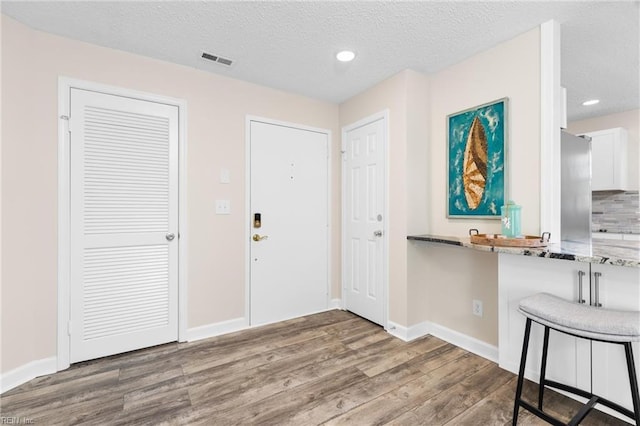 foyer with wood-type flooring and a textured ceiling