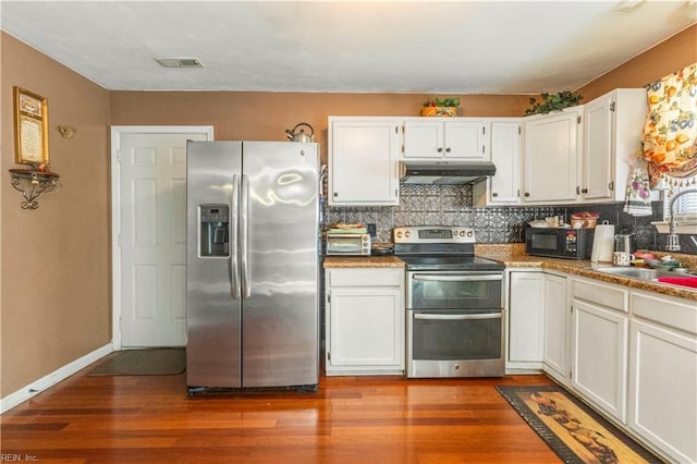 kitchen with decorative backsplash, appliances with stainless steel finishes, sink, hardwood / wood-style flooring, and white cabinets