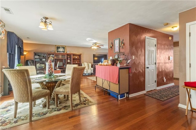 dining space with hardwood / wood-style floors and ceiling fan with notable chandelier