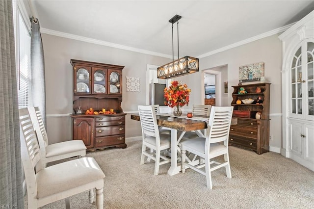 carpeted dining room with ornamental molding