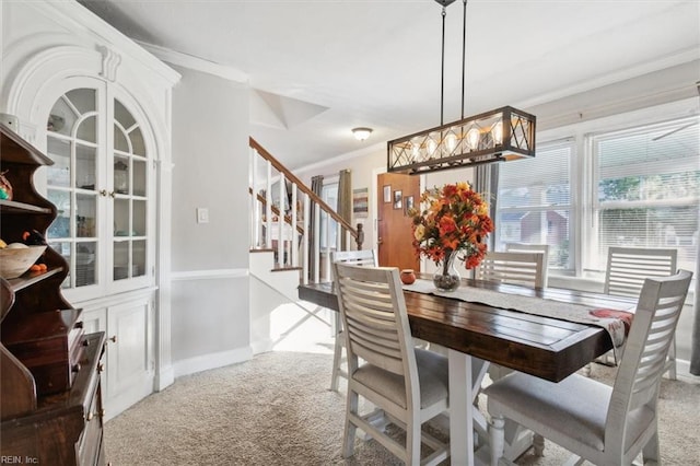 dining area with carpet and crown molding