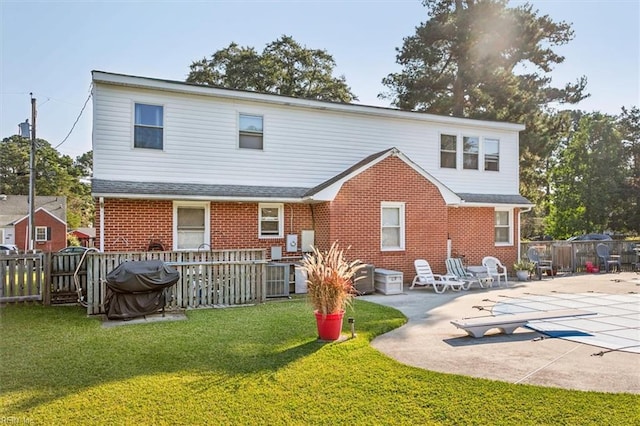 rear view of property featuring a yard and a patio area