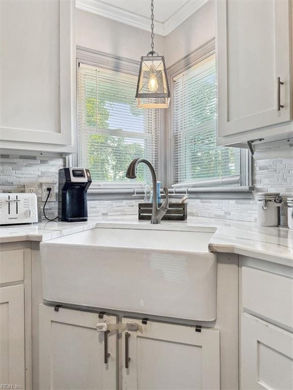 kitchen with backsplash, sink, and white cabinets