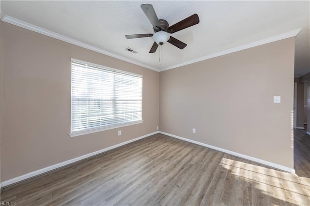 spare room featuring hardwood / wood-style floors, ceiling fan, and crown molding