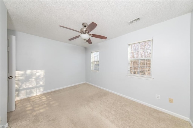 carpeted spare room with a textured ceiling and ceiling fan