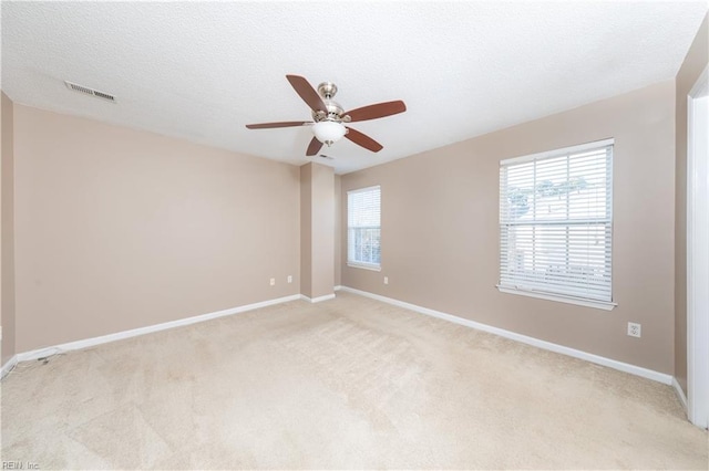 carpeted spare room with a textured ceiling and ceiling fan