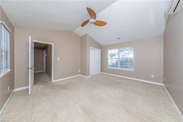 unfurnished bedroom with a wall mounted air conditioner, lofted ceiling, light carpet, ceiling fan, and a closet