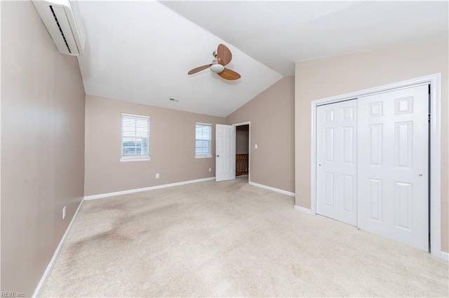 unfurnished bedroom featuring light carpet, vaulted ceiling, ceiling fan, a wall mounted AC, and a closet