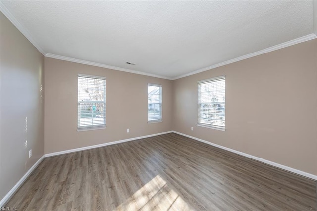 unfurnished room featuring hardwood / wood-style floors, ornamental molding, and a healthy amount of sunlight