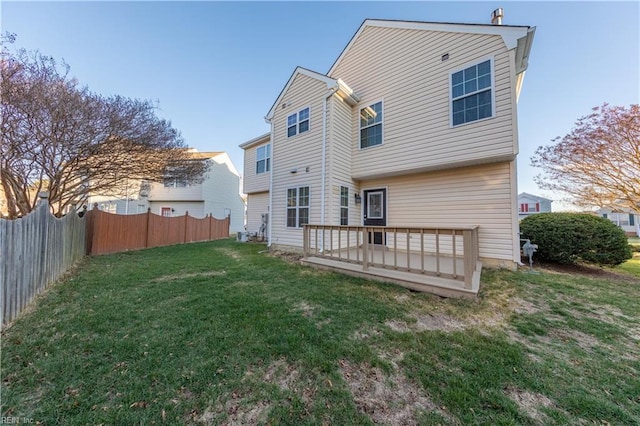 rear view of house featuring a deck and a lawn