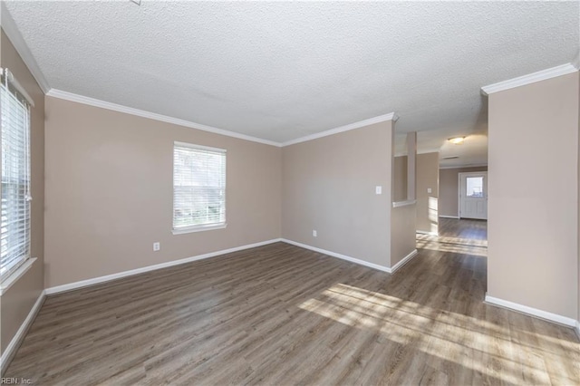 empty room with dark hardwood / wood-style floors, ornamental molding, and a textured ceiling