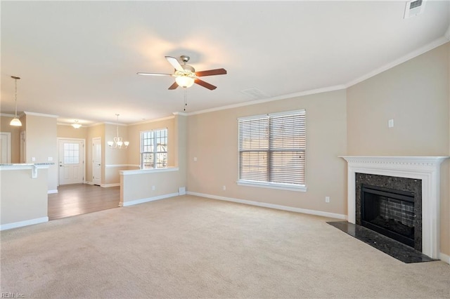 unfurnished living room featuring carpet, ceiling fan with notable chandelier, and crown molding