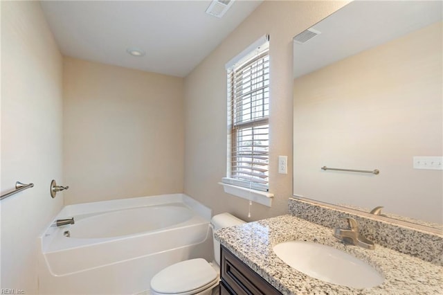 bathroom with a bathing tub, vanity, and toilet