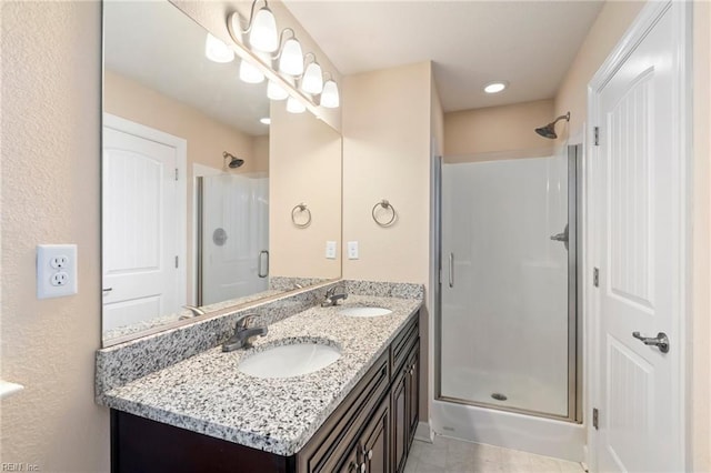 bathroom featuring tile patterned flooring, vanity, and a shower with door