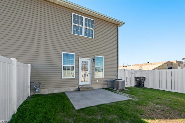 back of property featuring central air condition unit, a patio area, and a lawn