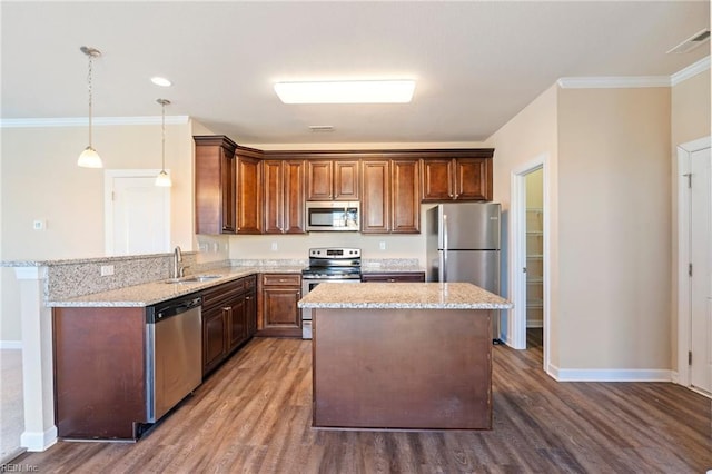 kitchen featuring pendant lighting, light stone counters, sink, and stainless steel appliances