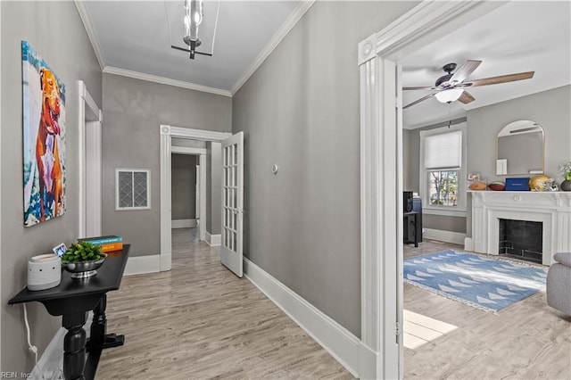 corridor featuring french doors, light wood-type flooring, and crown molding