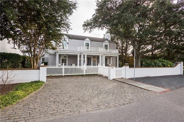 view of front of property featuring covered porch and a balcony