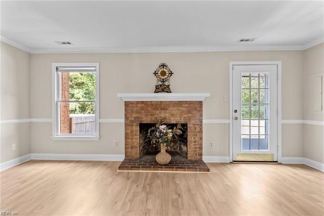 unfurnished living room with hardwood / wood-style flooring, a brick fireplace, and crown molding