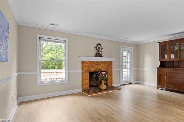 unfurnished living room featuring crown molding, light hardwood / wood-style floors, and a brick fireplace