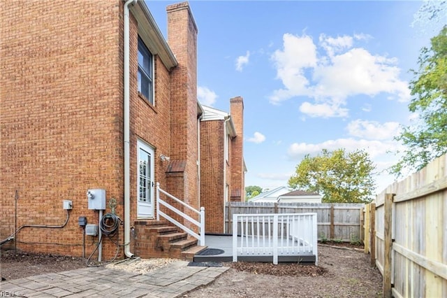 view of home's exterior featuring a patio area and a wooden deck