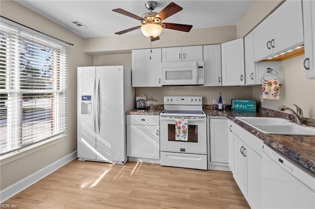 kitchen with sink, white cabinets, light hardwood / wood-style floors, and white appliances