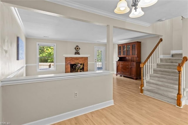 unfurnished living room with light hardwood / wood-style floors, crown molding, and a fireplace