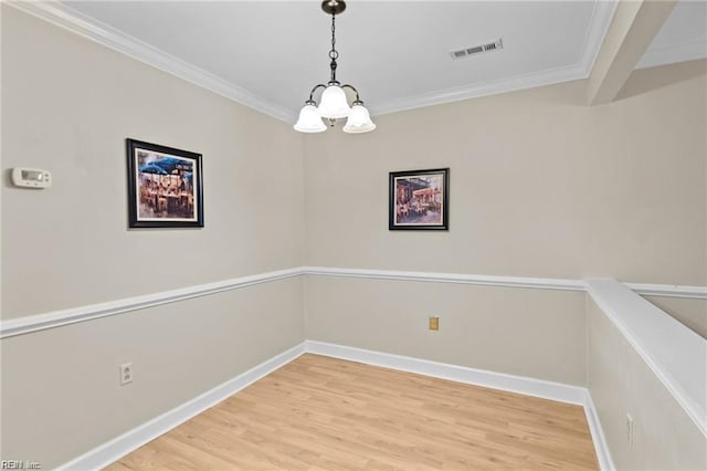 unfurnished dining area featuring crown molding, hardwood / wood-style floors, and a chandelier