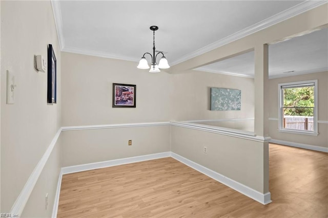 unfurnished dining area with light hardwood / wood-style floors, ornamental molding, and a chandelier