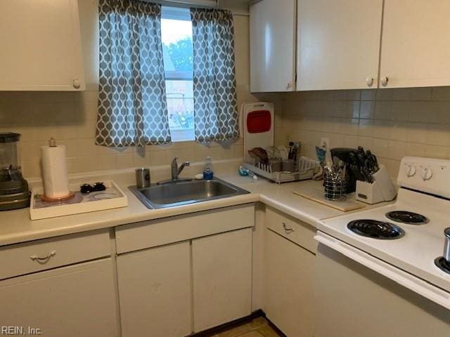 kitchen featuring decorative backsplash, white cabinetry, white range with electric cooktop, and sink