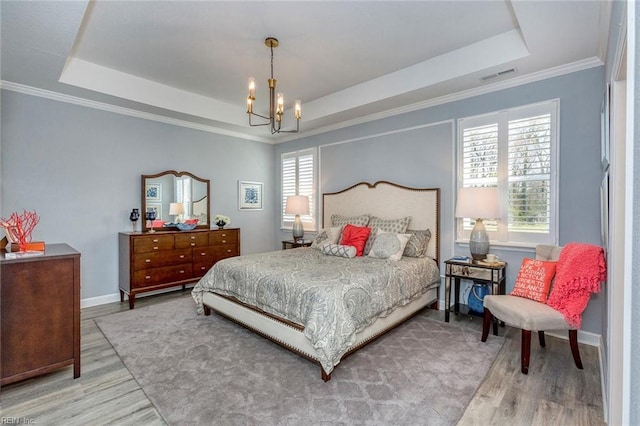 bedroom with a tray ceiling and light hardwood / wood-style flooring