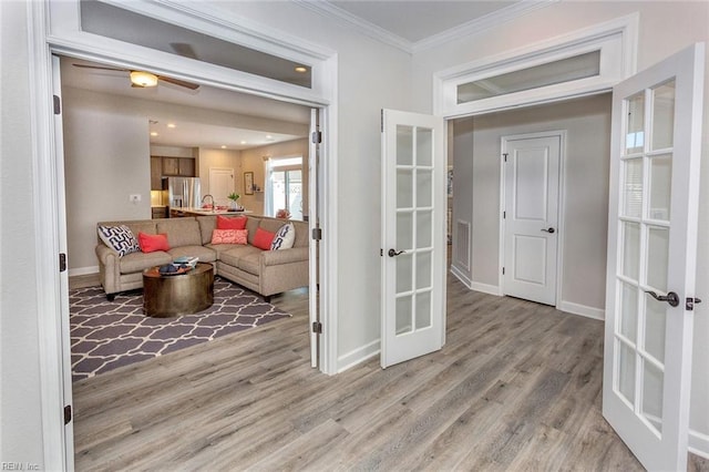 living room with ceiling fan, french doors, light hardwood / wood-style floors, and ornamental molding