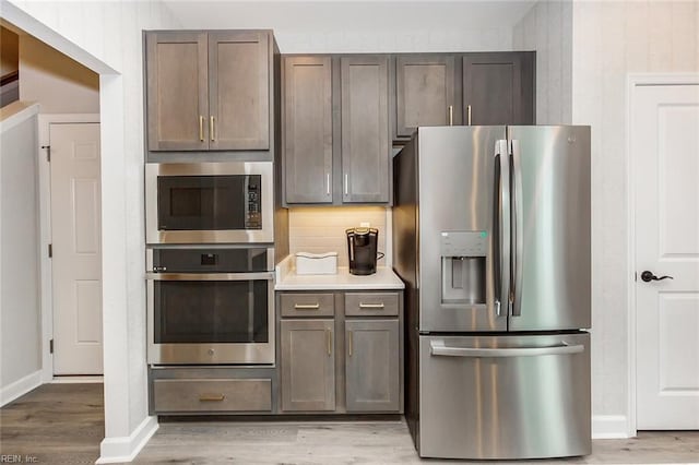 kitchen featuring decorative backsplash, light hardwood / wood-style floors, stainless steel refrigerator with ice dispenser, and built in microwave