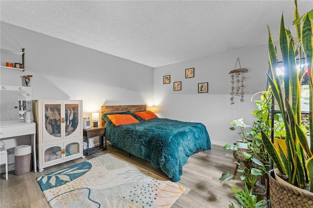 bedroom featuring a textured ceiling and light hardwood / wood-style flooring