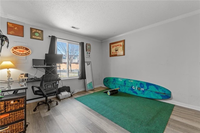 home office with wood-type flooring, a textured ceiling, and ornamental molding