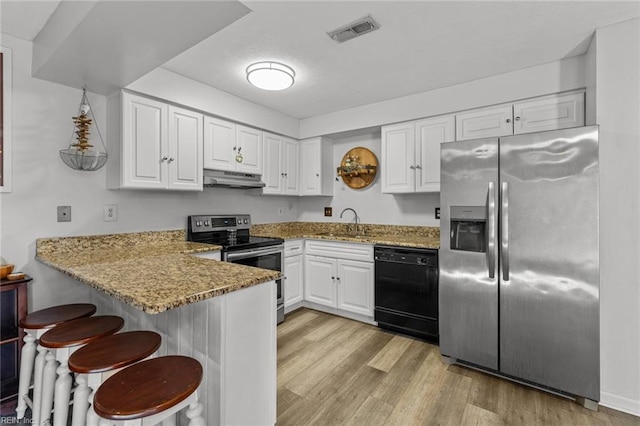 kitchen featuring kitchen peninsula, appliances with stainless steel finishes, sink, stone counters, and white cabinets