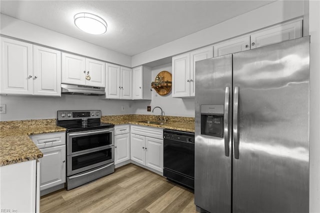 kitchen with white cabinets, sink, dark stone countertops, light hardwood / wood-style floors, and stainless steel appliances