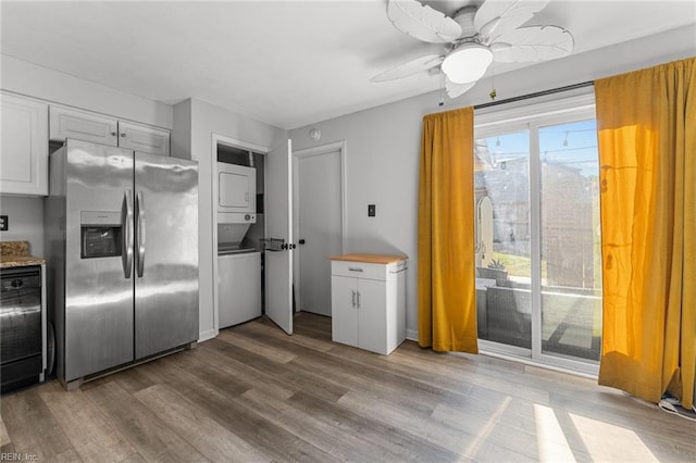 kitchen with stainless steel fridge with ice dispenser, white cabinetry, ceiling fan, and stacked washer and clothes dryer