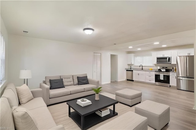 living room featuring light wood-type flooring and sink