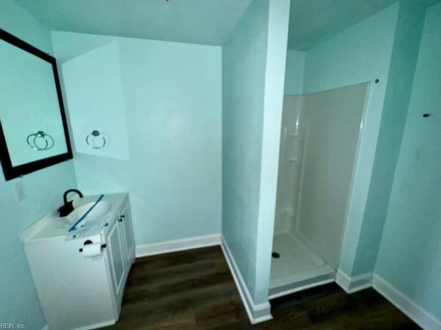 bathroom featuring vanity, wood-type flooring, and walk in shower