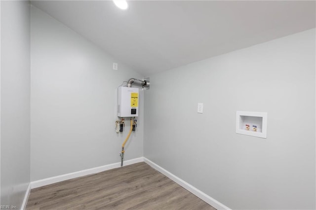 laundry area featuring washer hookup, tankless water heater, and hardwood / wood-style flooring