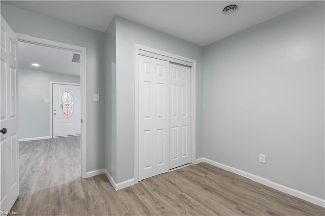 unfurnished bedroom featuring light hardwood / wood-style flooring and a closet