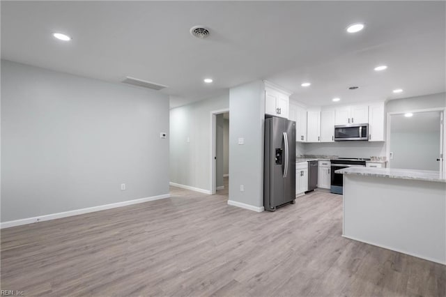 kitchen with light stone countertops, white cabinetry, stainless steel appliances, and light wood-type flooring