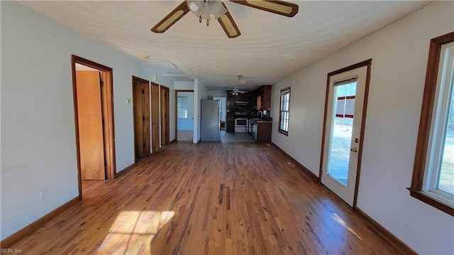 hallway with hardwood / wood-style floors, plenty of natural light, and sink