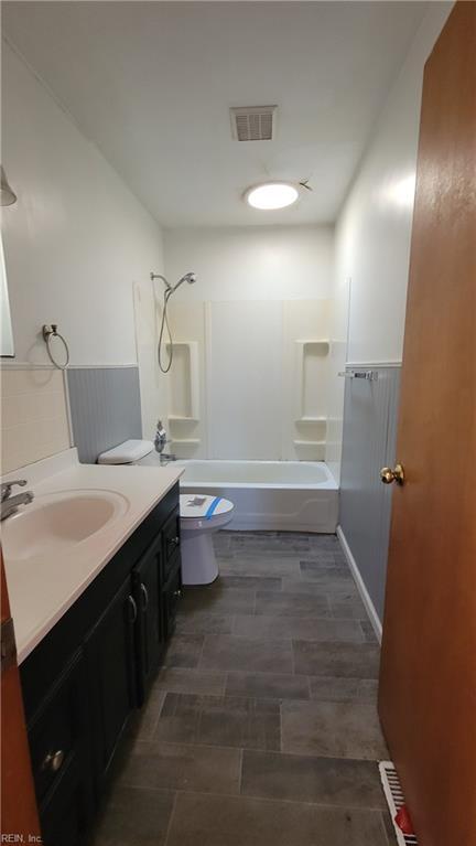 full bathroom with bathtub / shower combination, vanity, and toilet