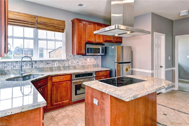 kitchen with appliances with stainless steel finishes, light stone counters, island range hood, sink, and a center island