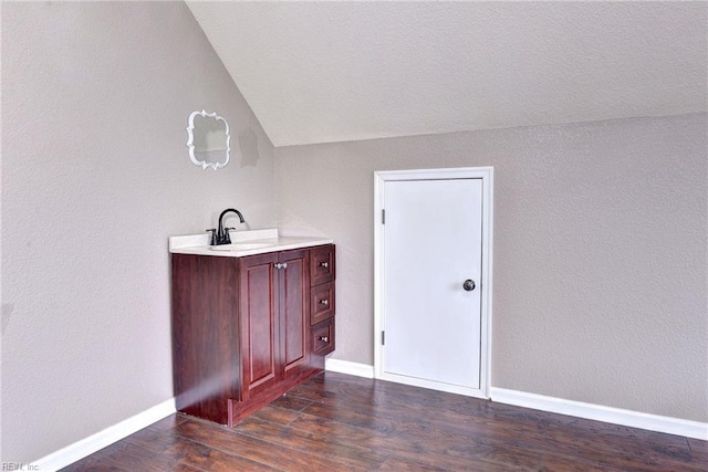 bathroom with wood-type flooring, vanity, and vaulted ceiling