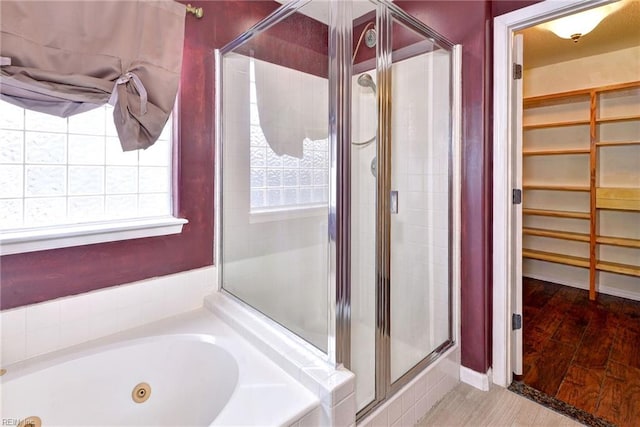 bathroom with hardwood / wood-style floors and independent shower and bath