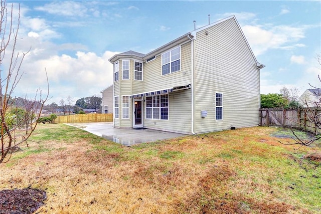 back of property with a lawn and a patio