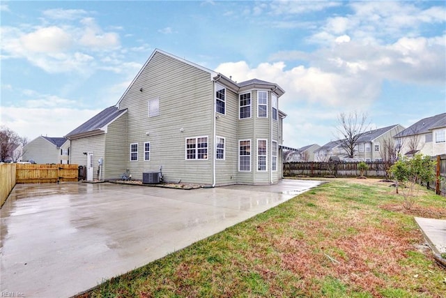 back of house featuring cooling unit, a yard, and a patio